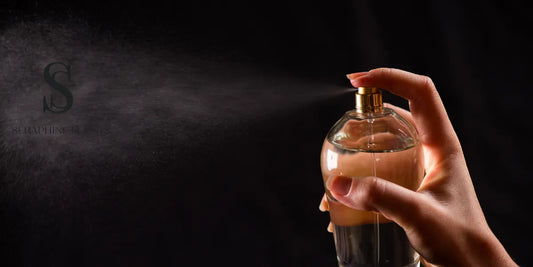 A hand spraying perfume from a glass bottle against a dark background with mist dispersing and the Seraphine Scents logo subtly visible.