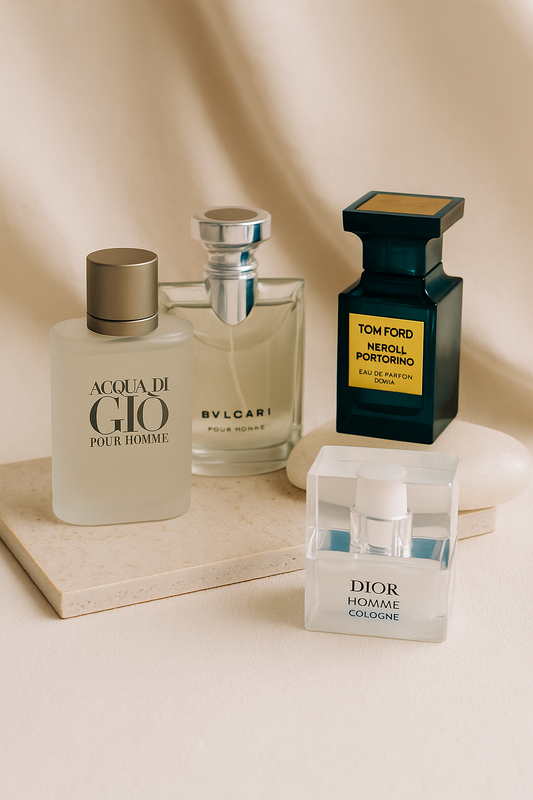 Four elegant perfume bottles—Armani Acqua di Gio, Bvlgari Pour Homme, Tom Ford Neroli Portofino, and Dior Homme Cologne—arranged on a beige surface with soft lighting, representing ideal office scents for Singapore professionals.