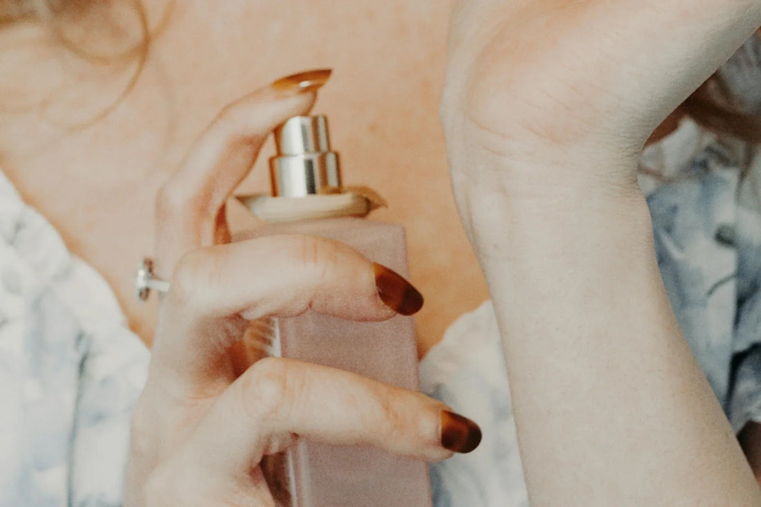 Applying Creed Silver Mountain Water perfume on wrist with luxury spray bottle close-up in Singapore 