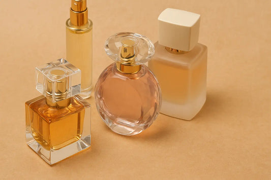 Four elegant perfume bottles arranged on a beige surface, highlighting sale-worthy fragrance designs for Singapore shoppers