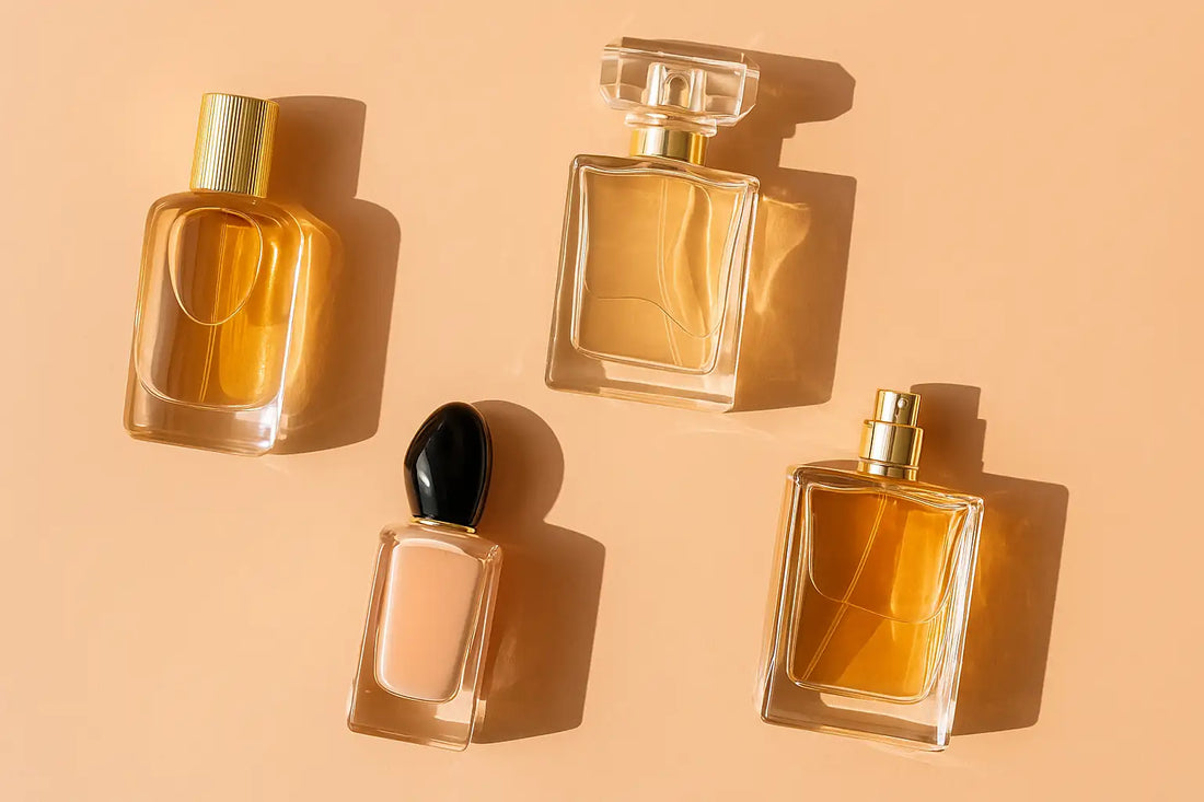 A digital photograph displays four uniquely designed perfume bottles arranged on a soft peach background, representing affordable luxury fragrance options in Singapore.