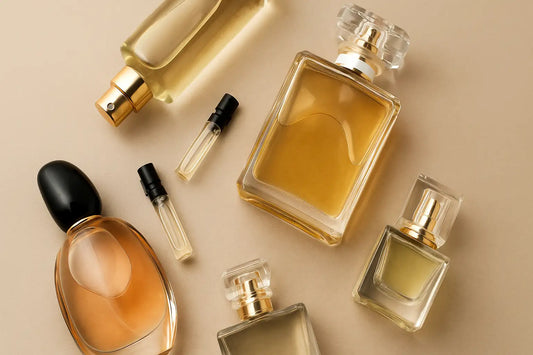 A digital photograph displays perfume bottles and sample vials arranged on a soft beige background, symbolizing fragrance discovery and sampling.